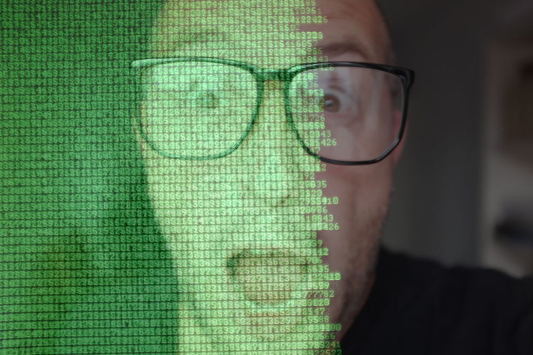 Digital composite image of shocked man against computer language