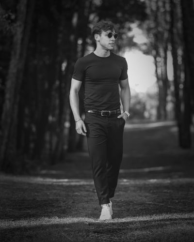 Rear view of man walking on footpath in forest