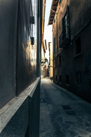 Empty narrow alley amidst buildings in city
