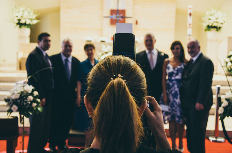 Rear view of woman photographing friends during event