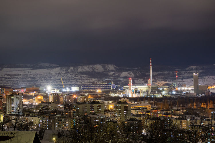 Illuminated cityscape against sky at night