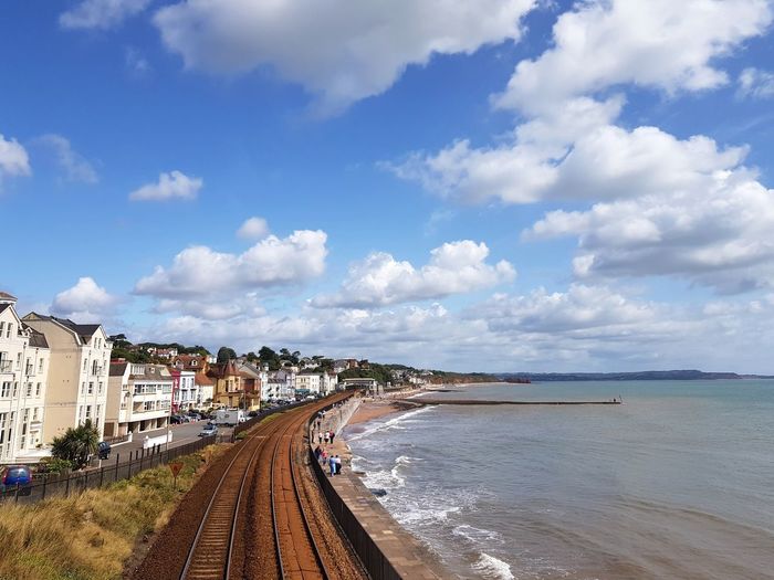 Panoramic view of railroad tracks by sea against sky