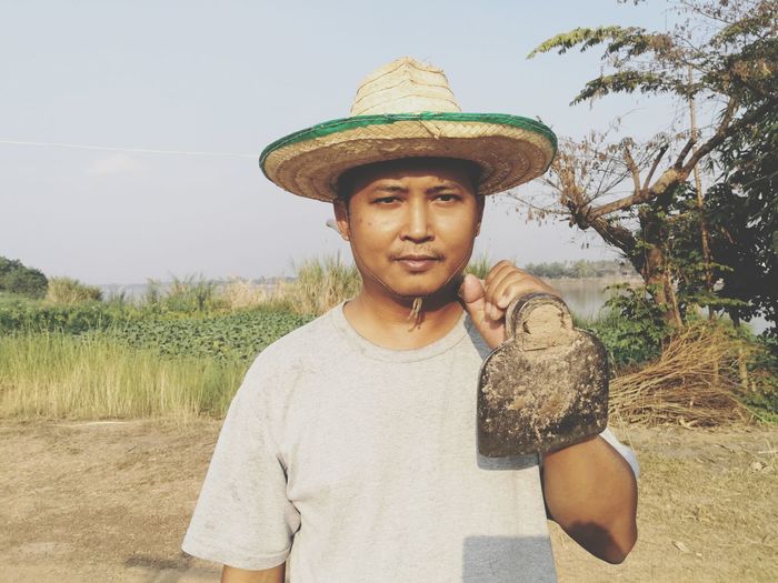 Portrait of farmer wearing hat on field