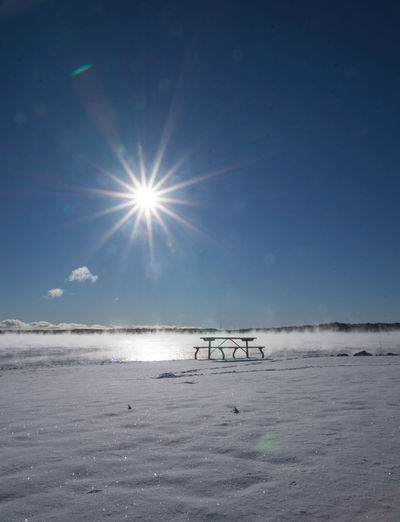Scenic view of frozen sea against sky on sunny day