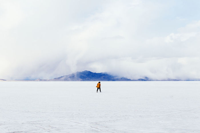 Distance shot of woman walking on snow covered landscape