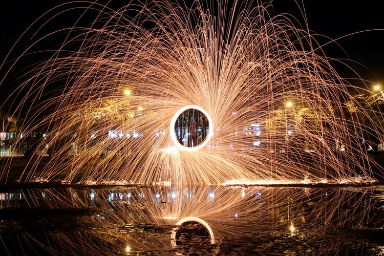 Wire wool spinning over wet street at night