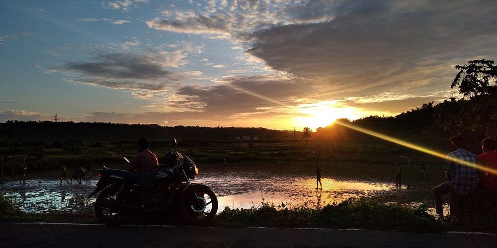 People riding motorcycle on sky during sunset