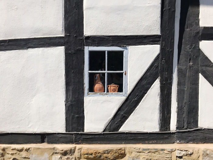 Window in historic timber framed black and white building wall