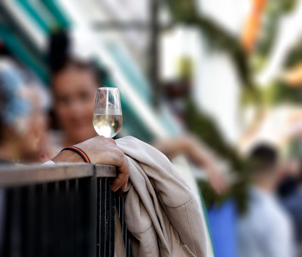 Cropped hand of person holding wineglass outdoors
