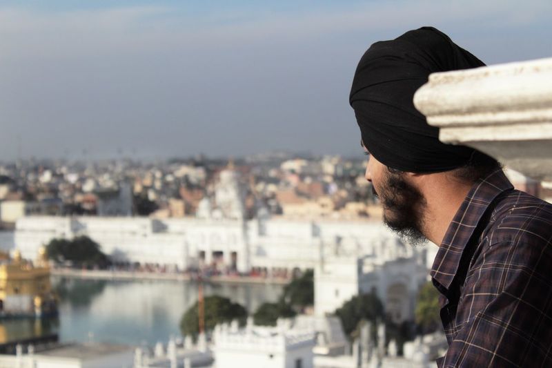 Side view of young man looking at cityscape