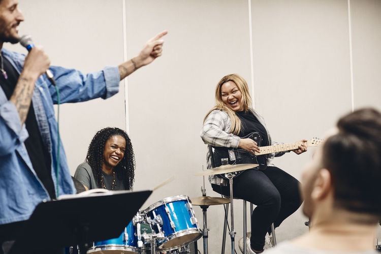 Happy multiracial men and women enjoying during rehearsal in classroom
