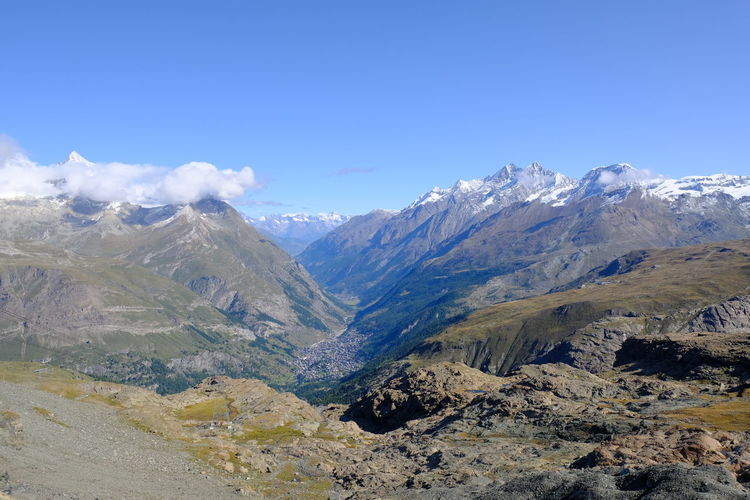 Scenic view of snowcapped mountains against blue sky