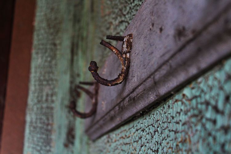 Close-up of rusty loop on weathered wall