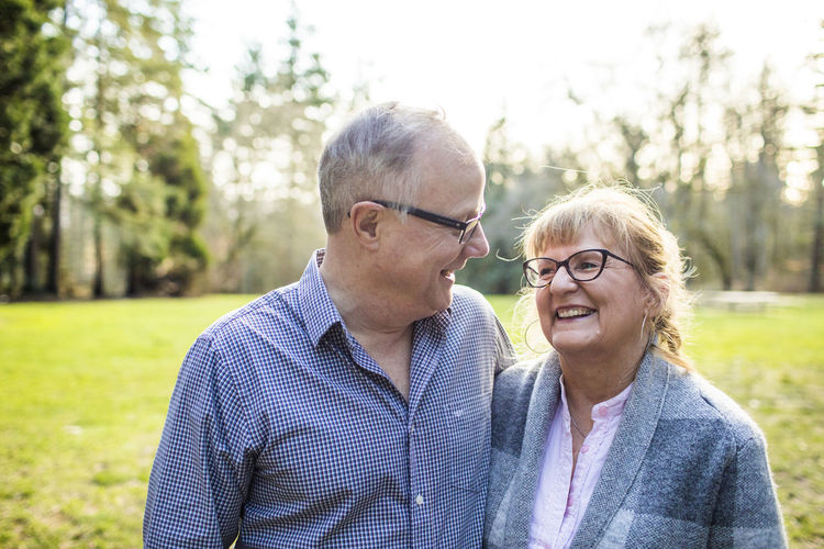 Cute elderly couple laughing and smiling together outdoors.