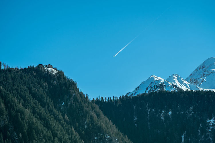 Low angle view of vapor trail against clear blue sky