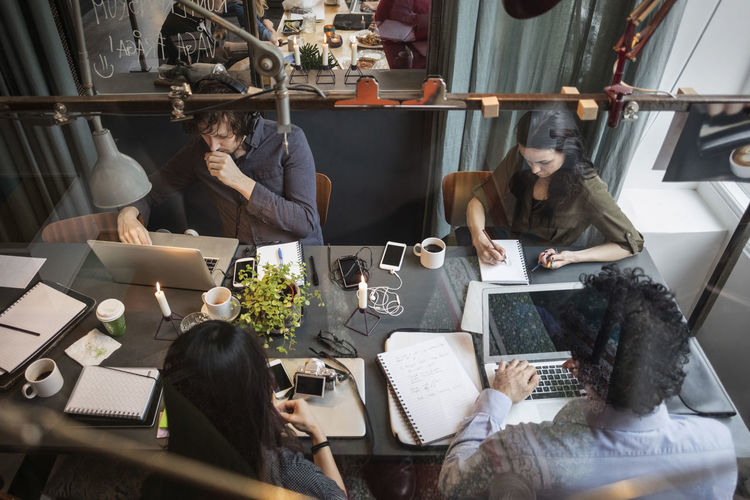 HIGH ANGLE VIEW OF PEOPLE WORKING IN OFFICE