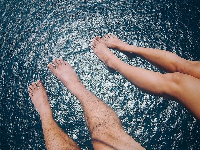 Low section of people feet in water