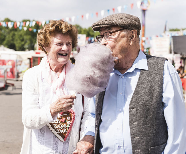 Senior couple on fair enjoying cotton candy