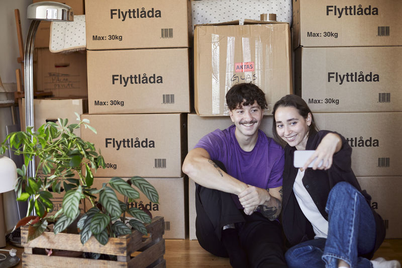 Couple taking selfie while moving house