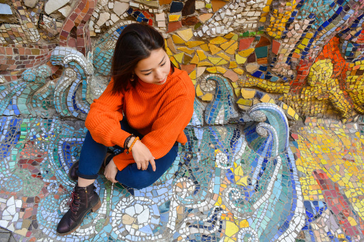 Full length of woman sitting by water