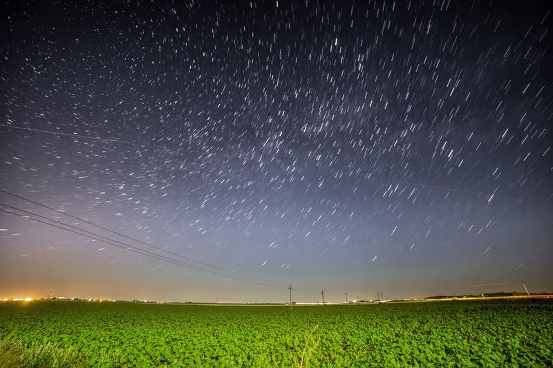 Scenic view of grassy field against sky at night