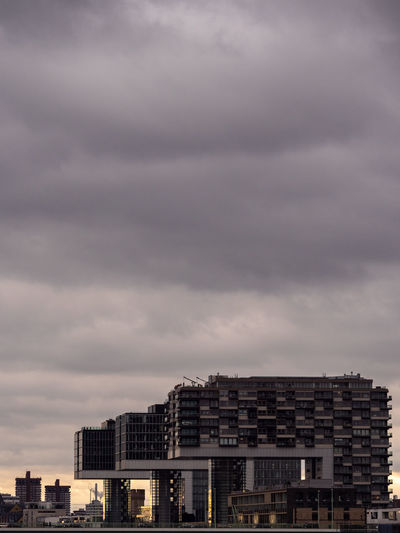 Buildings in city against cloudy sky