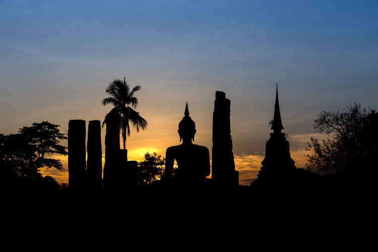 Silhouette of statues at sunset