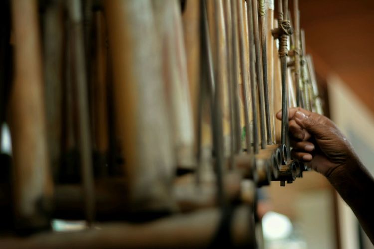 Cropped hand of person touching musical instrument indoors