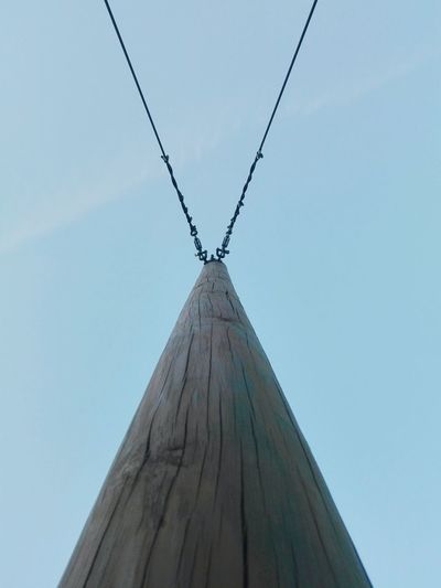 Low angle view of wooden pole with cables against sky