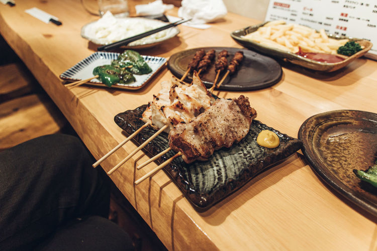 High angle view of yakitori and yakiton  served on table at izakaya restaurant in japan