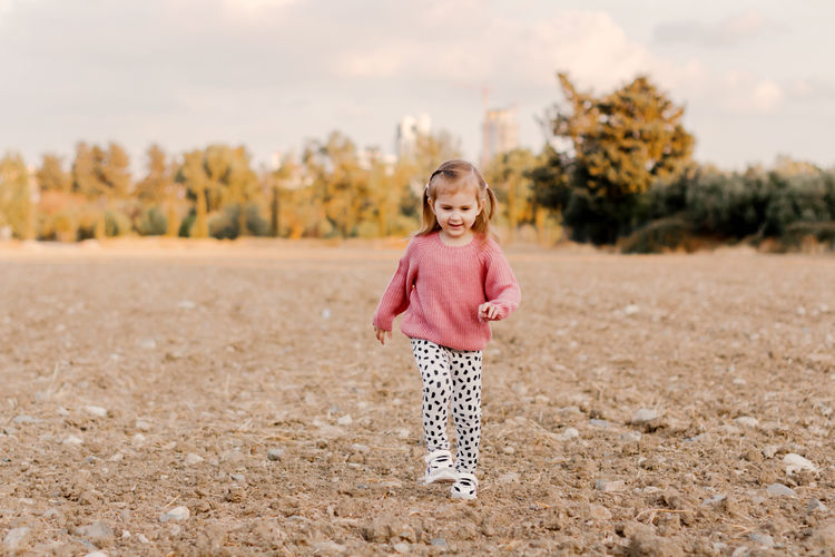 Portrait of young woman standing on field