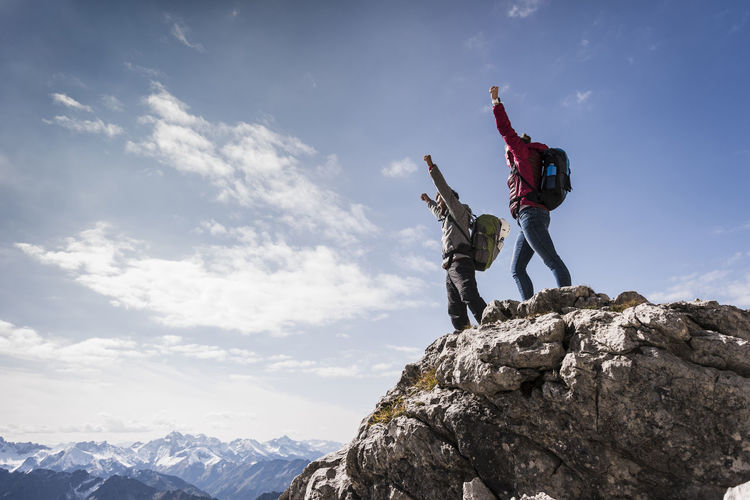 Germany, bavaria, oberstdorf, two hikers cheering on rock in alpine scenery