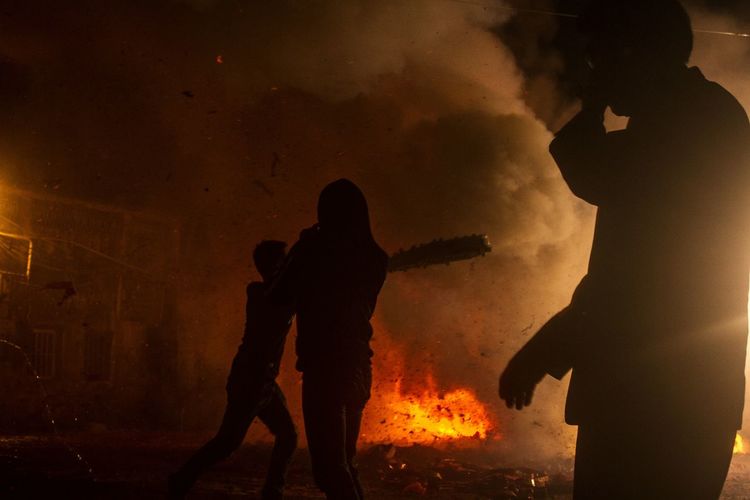 SILHOUETTE PEOPLE STANDING AGAINST ORANGE FIRE