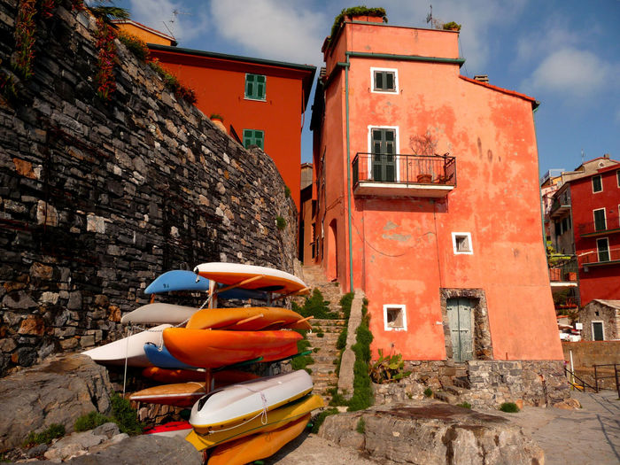 Kayaks on rack by stone wall against building