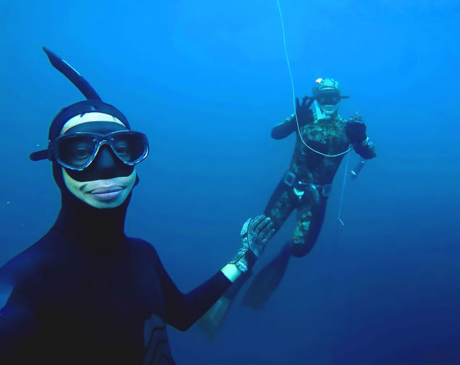 Portrait of man scuba diving with friend in sea