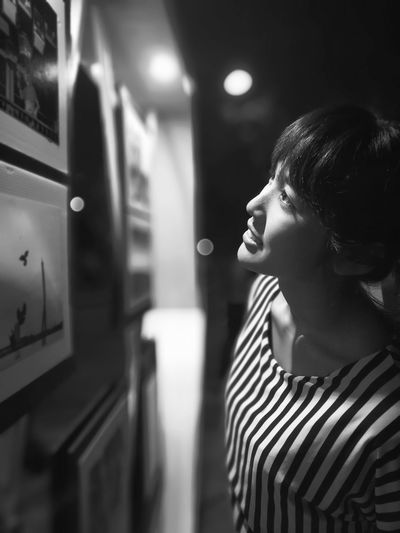Smiling young woman looking at picture frames