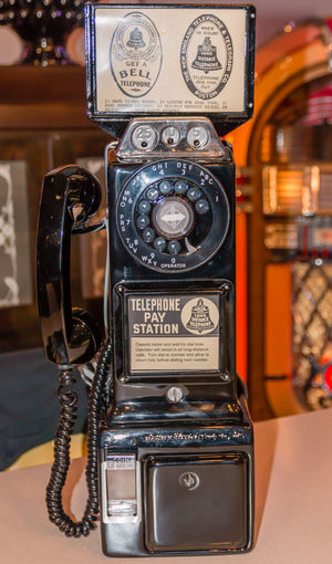 Close-up of old telephone booth on table
