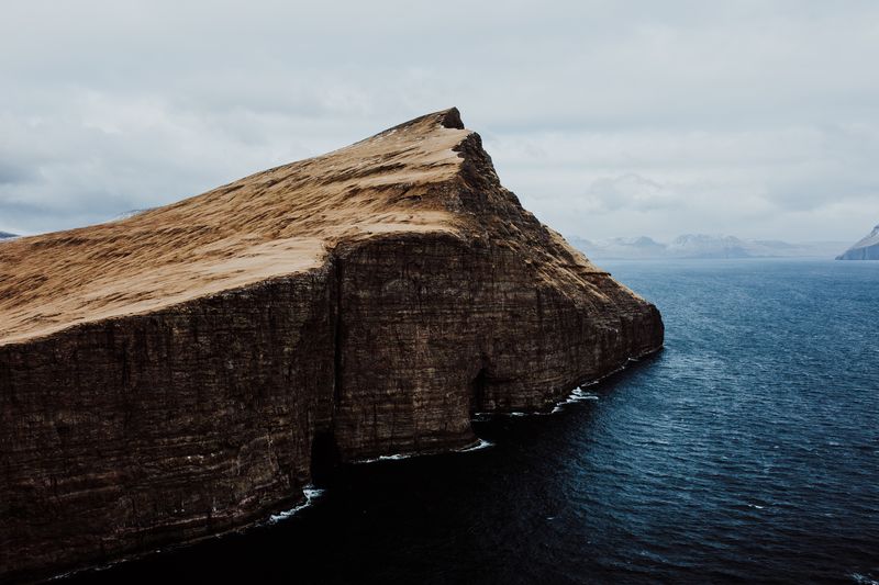 Rock formation by sea against sky