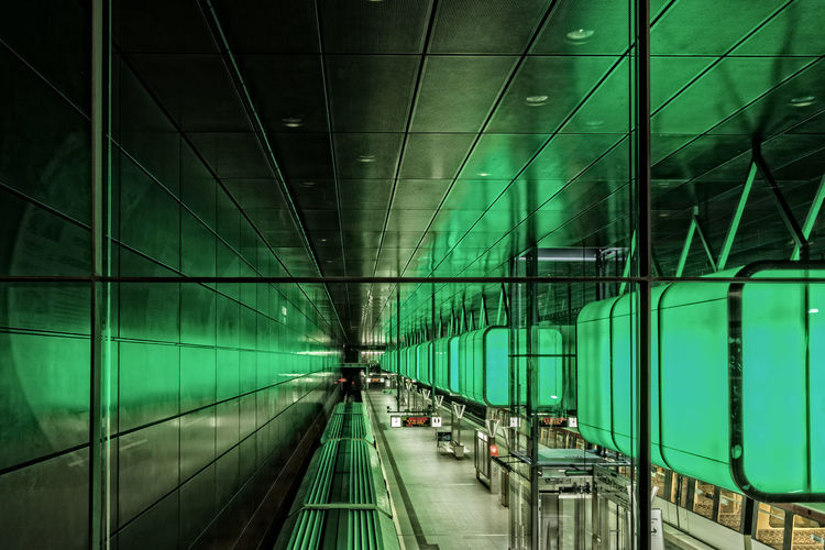 Illuminated green lights at hafencity universitat seen through glass