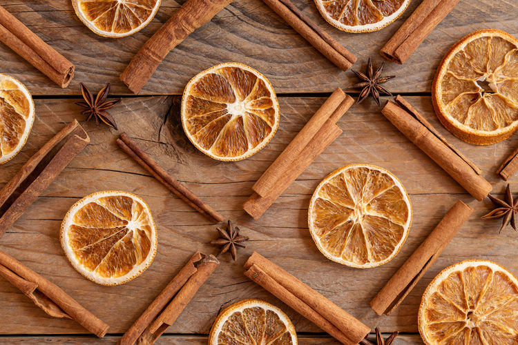 Cinnamon sticks, slices of dried orange, star anise on wooden background. top view. christmas 