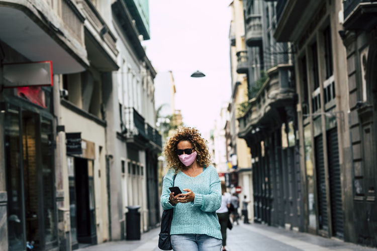 Portrait of woman standing on street in city