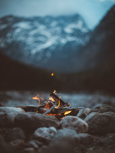 Low angle view of fire on rock against sky