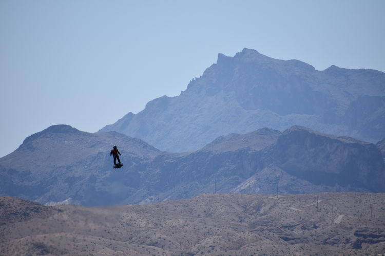Man on mountain against clear sky