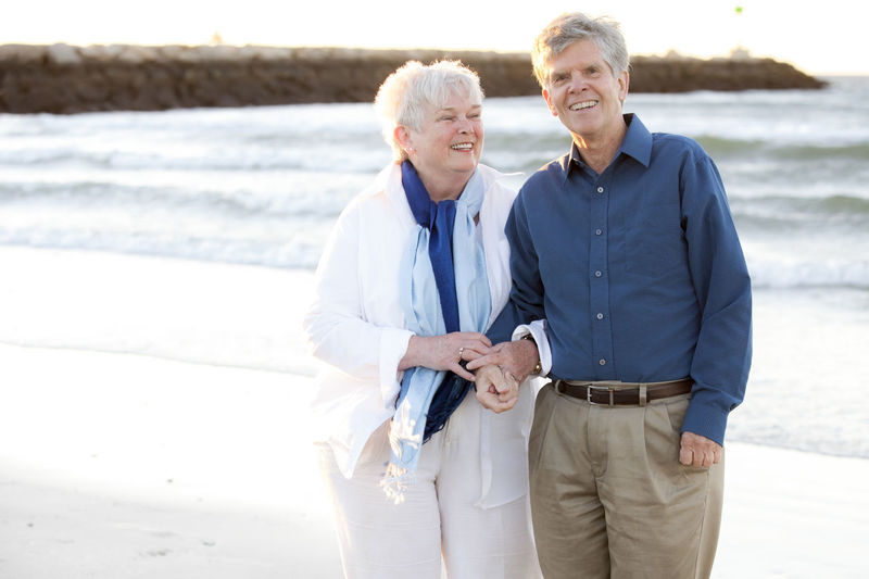 Married couple in their seventies showing affection at cold storage beach on cape cod