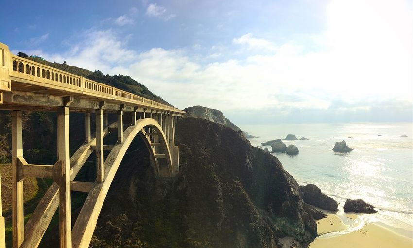 Arch bridge over sea against sky