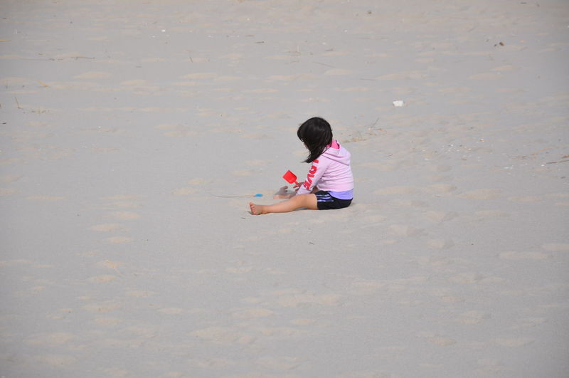 Side view of girl playing on beach