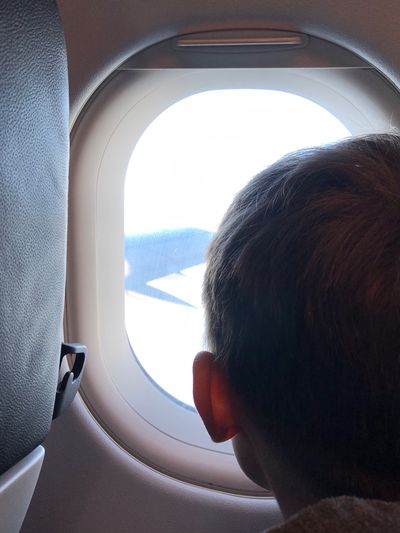 Portrait of boy seen through airplane window