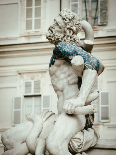 Low angle view of statue against building fabio viale sculpture 