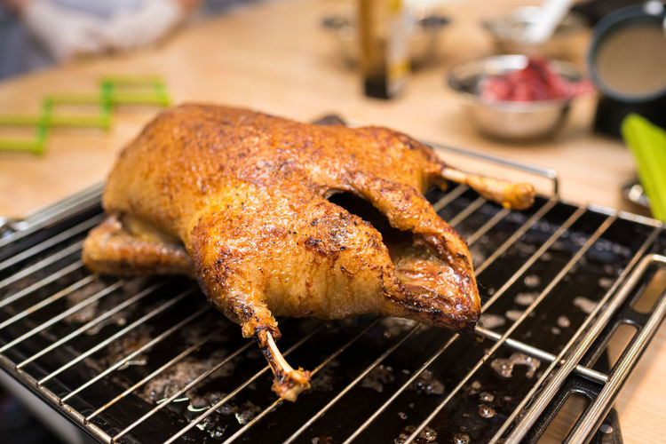 Baked duck on a rack and tray from the oven. the cooked duck cools. toasted to a crisp skin.