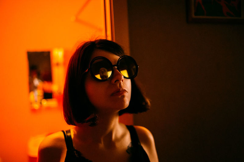 Young woman wearing sunglasses looking up